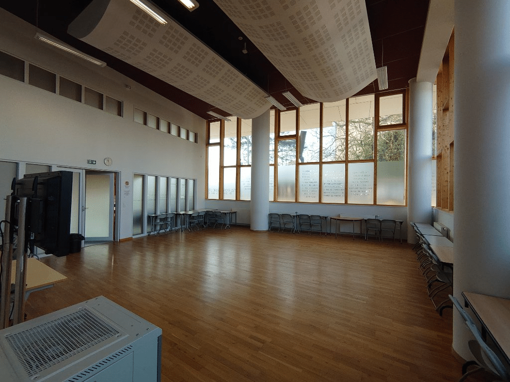 Salle lumineuse au parquet, aménagée pour la mise en pratique